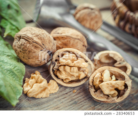 Open walnut close up, nutcracker and basket Open walnut close up, nutcracker and basket 28340653