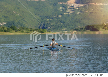 The young sportsman is rowing on the racing kayak 28341049