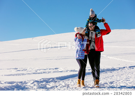 Attractive family having fun in a winter park on Attractive family having fun in a winter park on 28342803