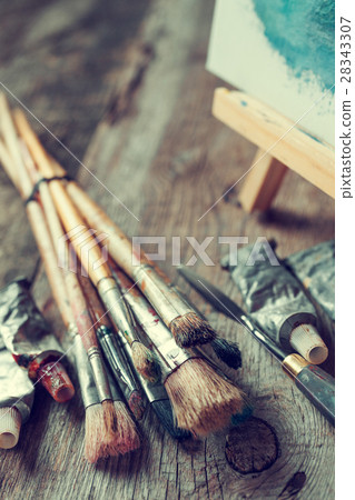 Artistic paintbrushes, oil paints and easel  28343307