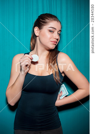 Young girl holding poker chips on blue background 28344580