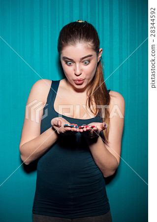 Young girl holding poker chips on blue background Young girl holding poker chips on blue background 28344592
