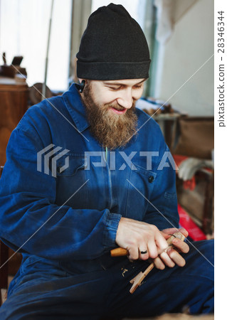 A man working with woodcarving instruments 28346344