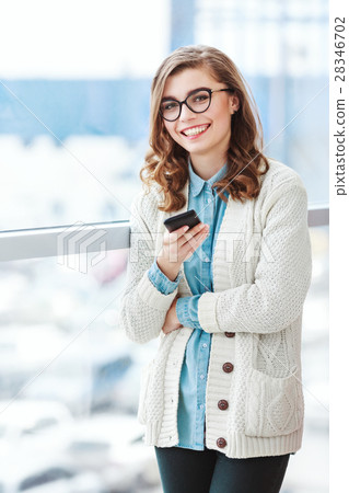 Lovely girl with glasses standing with mobile Lovely girl with glasses standing with mobile 28346702