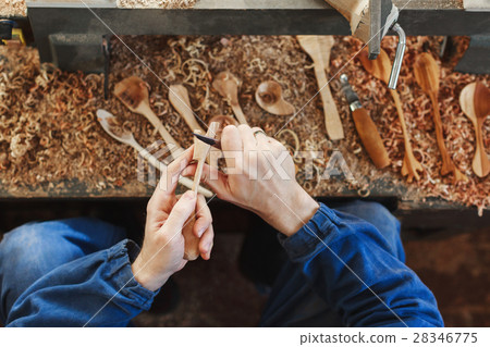 A man working with woodcarving instruments 28346775