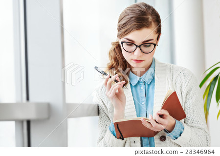 Lovely girl with glasses standing with notebook Lovely girl with glasses standing with notebook 28346964