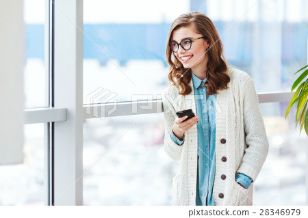 Lovely girl with glasses standing with mobile 28346979