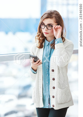 Lovely girl with glasses standing with mobile 28346980