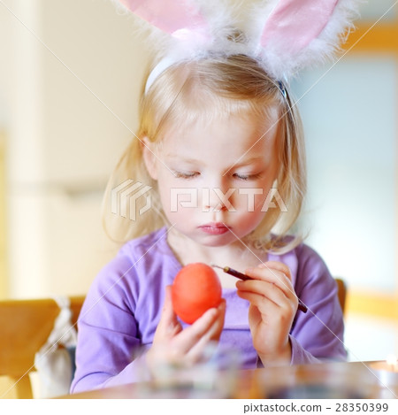 Adorable little girl painting colorful Easter eggs Adorable little girl painting colorful Easter eggs 28350399