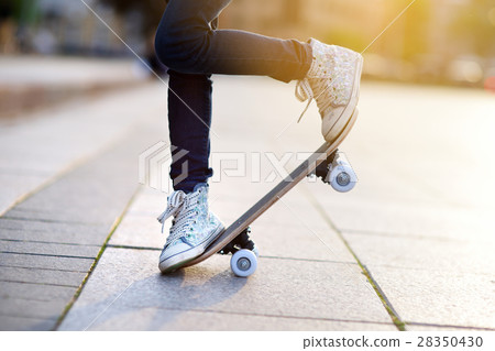 Closeup of skateboarder legs. Kid riding skateboard outdoor. 28350430