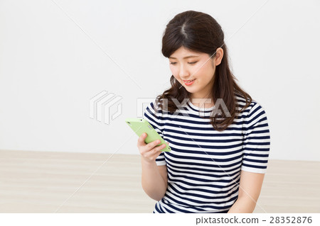 看智能手機的婦女在屋子裡 看智能手機的婦女在屋子裡 28352876