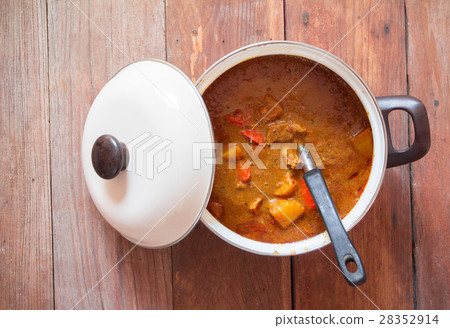Beef mussaman curry in a pot on wood background Beef mussaman curry in a pot on wood background 28352914