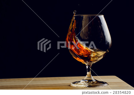 Bohemian glass of cognac on a wooden table 28354820