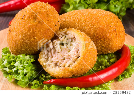 three fried breaded cutlet with lettuce on a three fried breaded cutlet with lettuce on a 28359482