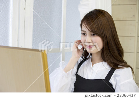 A young woman with a smile checking face and grooming while watching the mirror A young woman with a smile checking face and grooming while watching the mirror 28360437