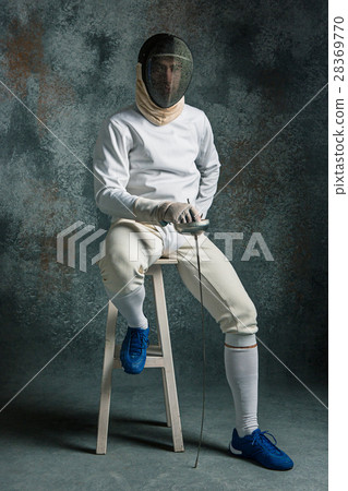 The man wearing fencing suit with sword against The man wearing fencing suit with sword against 28369770
