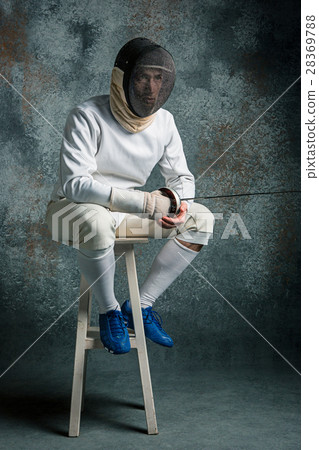 The man wearing fencing suit with sword against The man wearing fencing suit with sword against 28369788