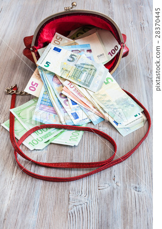 various euro banknotes fall out from red handbag 28370445