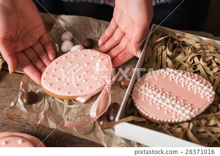 Woman packing handmade Easter cookies closeup Woman packing handmade Easter cookies closeup 28371016