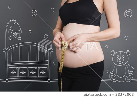 Pleasant pregnant woman using measure tape 28372008