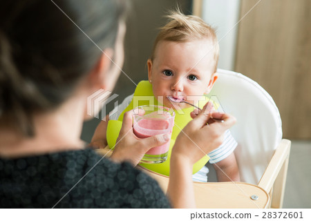 Unrecognizable mother feeding her baby daughter 28372601