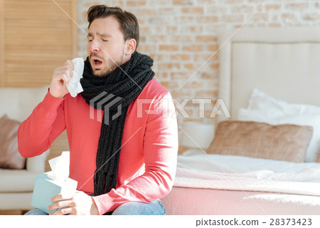 Young bearded man suffering from illness at home Young bearded man suffering from illness at home 28373423