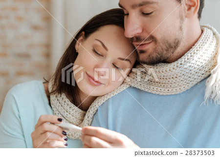 Smiling young couple relaxing at home Smiling young couple relaxing at home 28373503