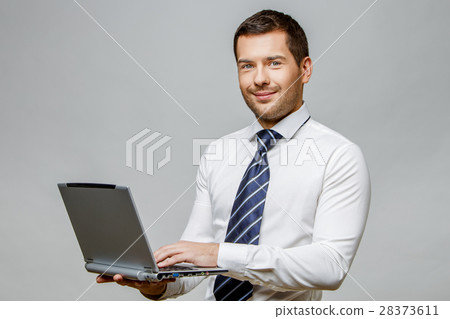 Handsome stylish businessman on grey background 28373611