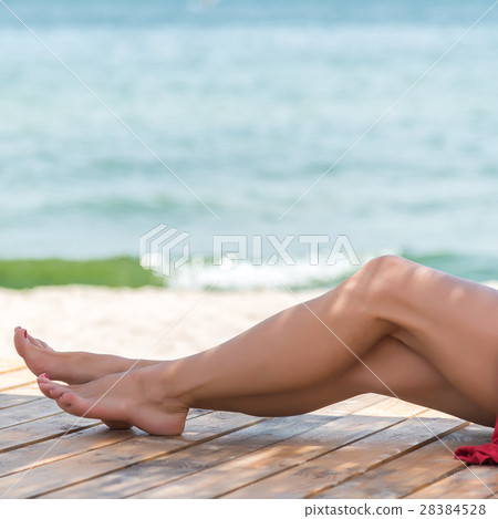 Woman's beautiful legs on the beach Woman's beautiful legs on the beach 28384528