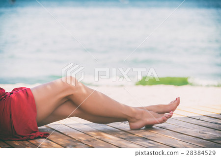 Woman's beautiful legs on the beach Woman's beautiful legs on the beach 28384529
