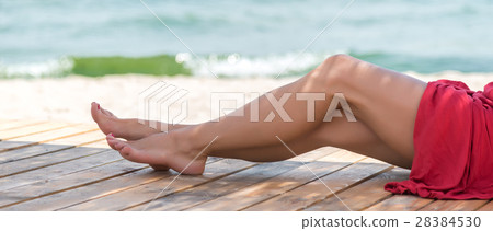 Woman's beautiful legs on the beach Woman's beautiful legs on the beach 28384530