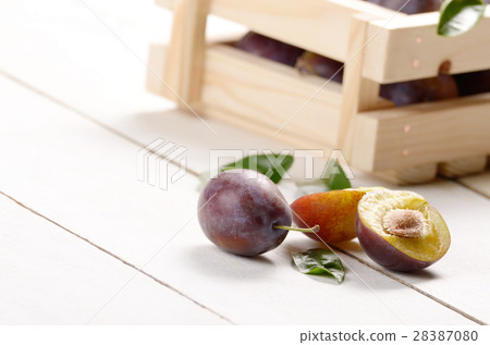 Wooden crate with plums closeup Wooden crate with plums closeup 28387080