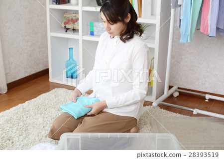 A woman who folds and stores clothes 28393519