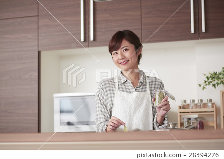 A woman standing in the kitchen A woman standing in the kitchen 28394276