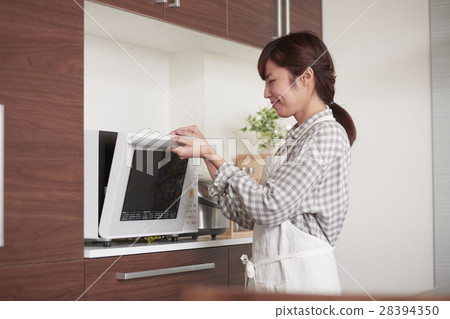 站在廚房裡使用微波爐的女性 28394350