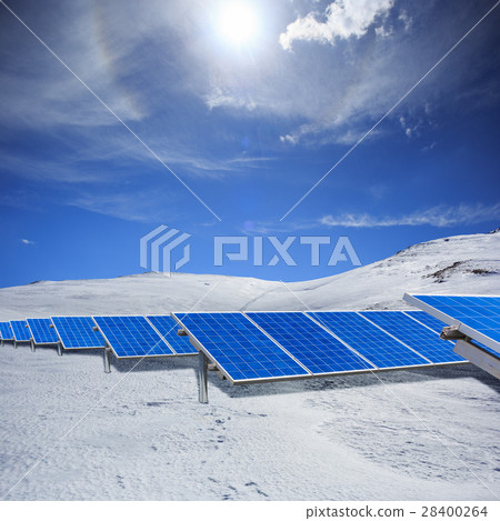 Modern solar station with blue panels standing in winter field w 28400264