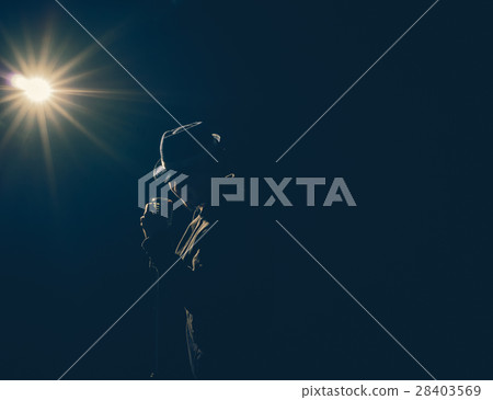 Asian Musician singing a song with microphone on black background with spot light and lens flare, musical concept Asian Musician singing a song with microphone on black background with spot light and lens flare, musical concept 28403569