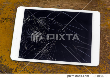 Tablet computer with broken glass screen on the wood background Tablet computer with broken glass screen on the wood background 28403690