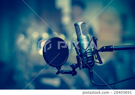 Professional condenser studio microphone over the musician blurred background, Musical instrument Concept Professional condenser studio microphone over the musician blurred background, Musical instrument Concept 28403691