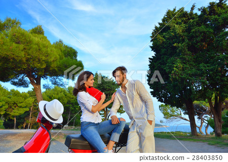 Portrait of happy young love couple on scooter Portrait of happy young love couple on scooter 28403850