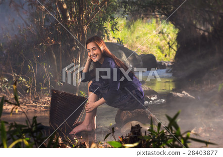 Portrait of beautiful Village women sitting and washing the clothes at the stream of waterfall or river, countryside and Folkways concept 28403877
