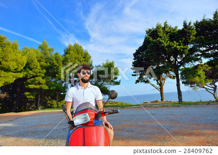 Handsome man riding a scooter on city streets on Handsome man riding a scooter on city streets on 28409762