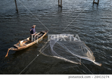 fisherman on wooden boat casting a net fisherman on wooden boat casting a net 28413274