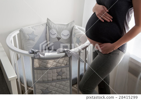 young pregnant girl in a gray dress standing young pregnant girl in a gray dress standing 28415299