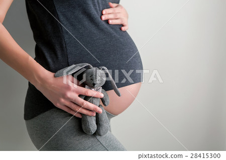 pregnant girl holding a toy rabbit pregnant girl holding a toy rabbit 28415300