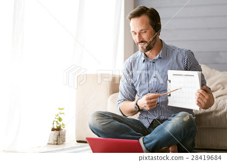 Involved bearded man using modern gadgets at home 28419684