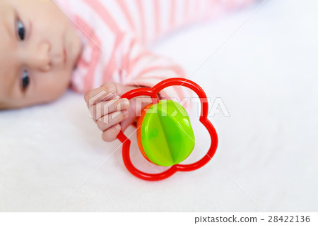 Cute baby girl playing with colorful rattle toy 28422136
