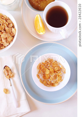 Corn flakes in bowl, milk and tea 28422610