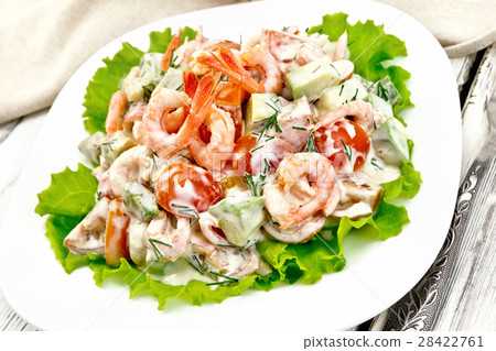 Salad with shrimp and avocado in plate on board Salad with shrimp and avocado in plate on board 28422761