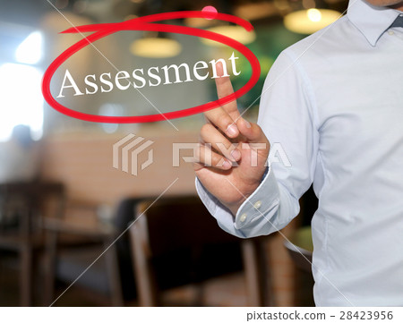Hand of man touching text Assessment. 28423956